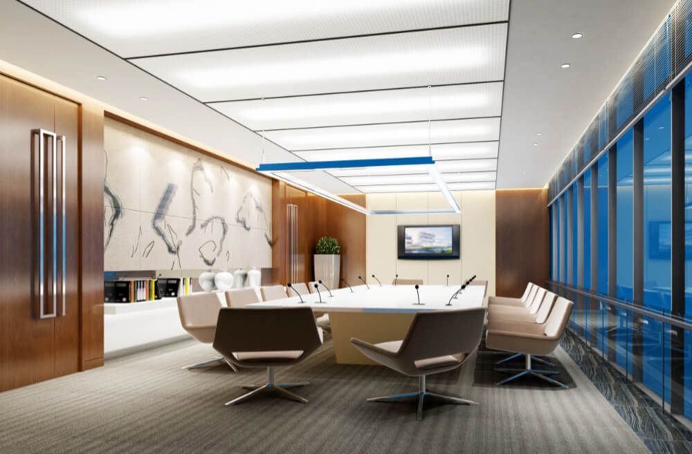 A conference room with a long table and chairs and a television on the wall.