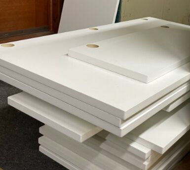 A stack of white boards with holes in them