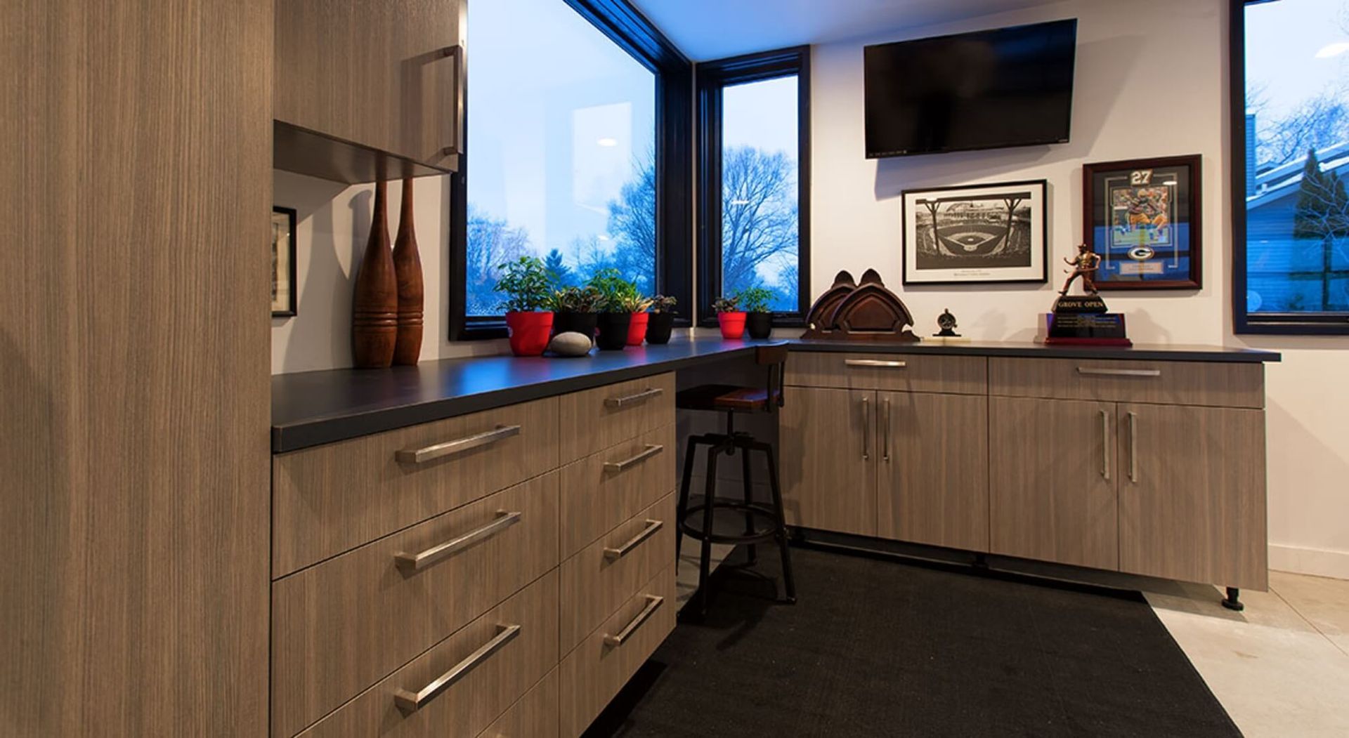 A kitchen with wooden cabinets and a flat screen tv on the wall.