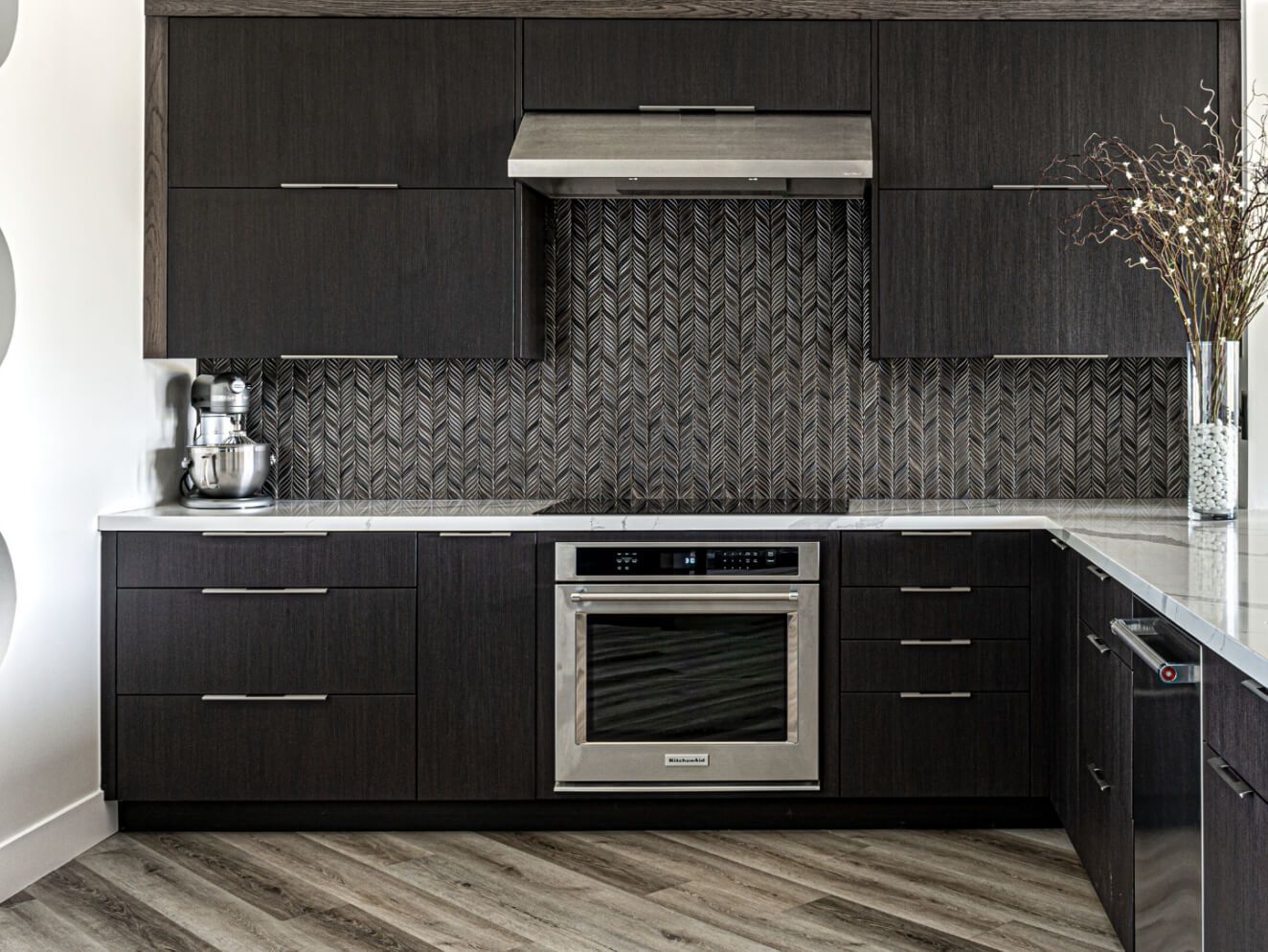 A kitchen with black cabinets and stainless steel appliances.
