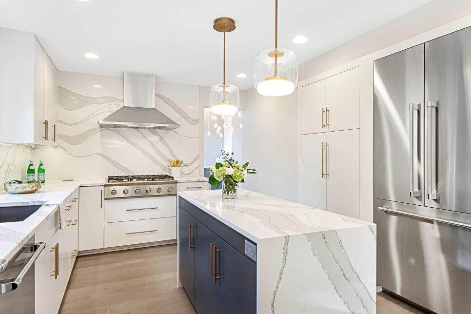 A kitchen with stainless steel appliances and a large island in the middle.