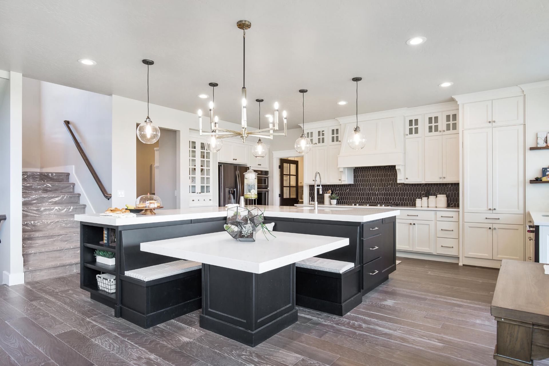 A kitchen with a table and benches in the middle of it.