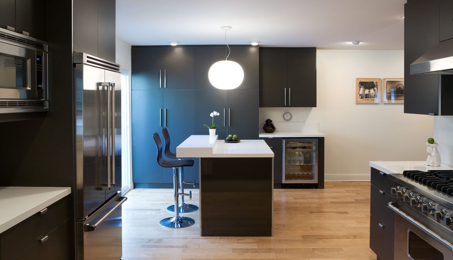 A kitchen with black cabinets and stainless steel appliances