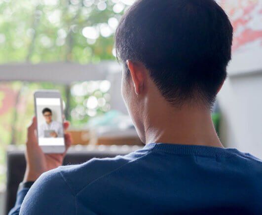 A man is holding a cell phone with a picture of a man on it.