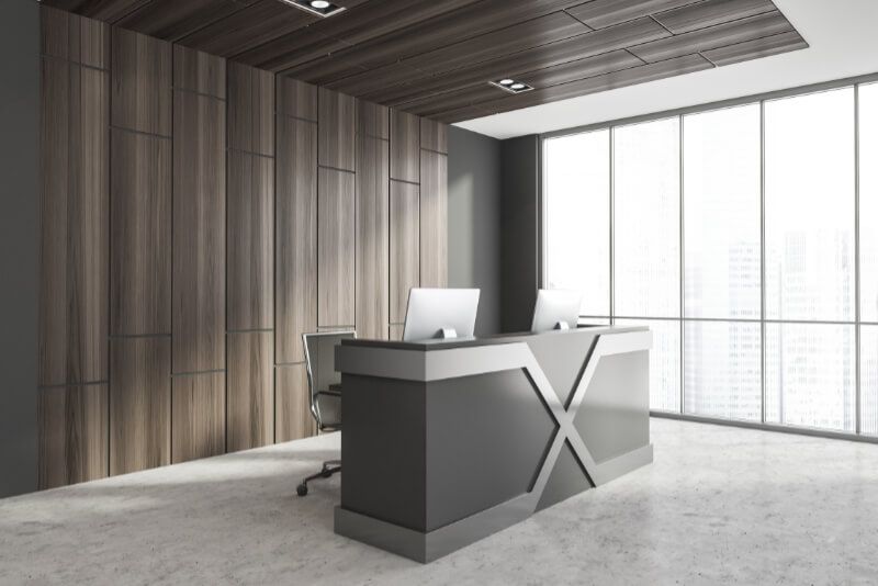 A reception desk in an office with a computer on it.