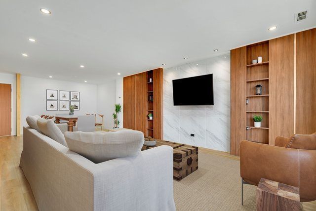 A living room with a couch , chair , and television.