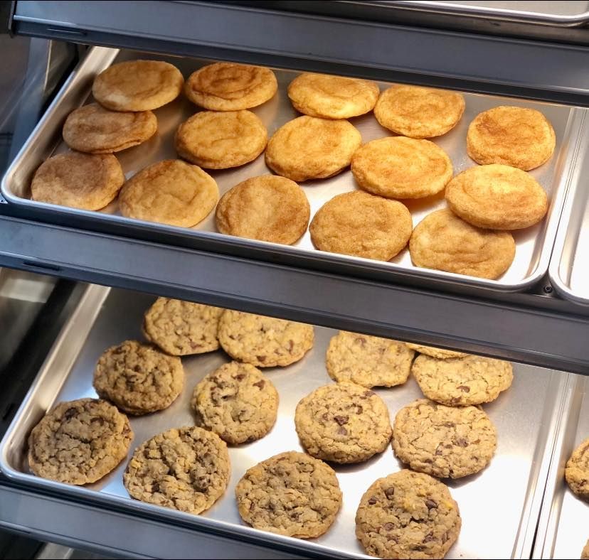 Three trays of cookies are lined up on a shelf