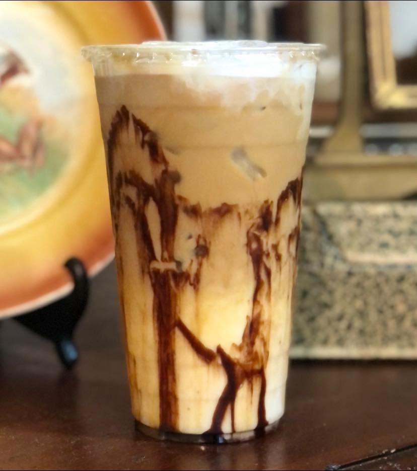 A cup of iced coffee with chocolate sauce on top