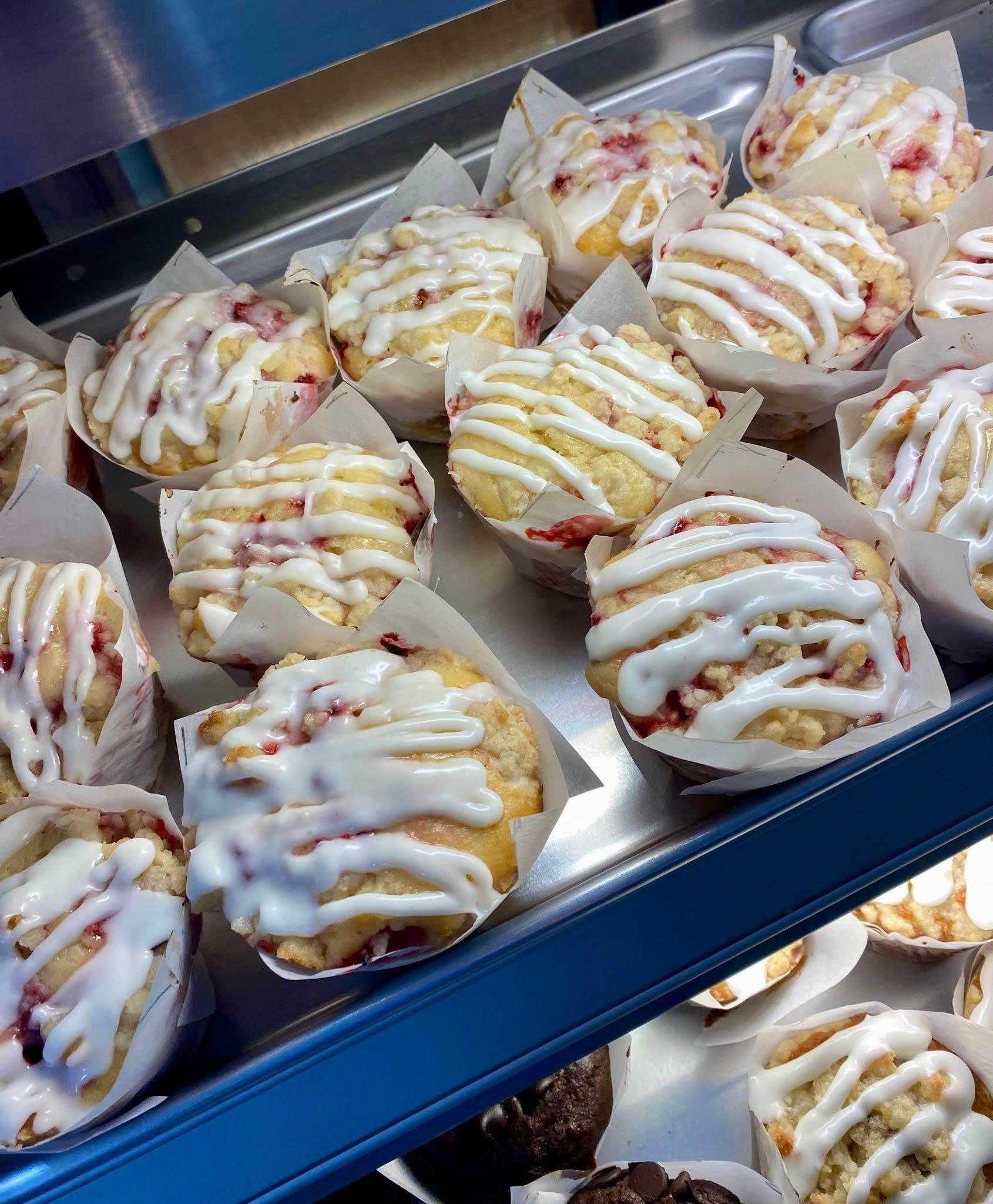 A tray of muffins with white frosting on them