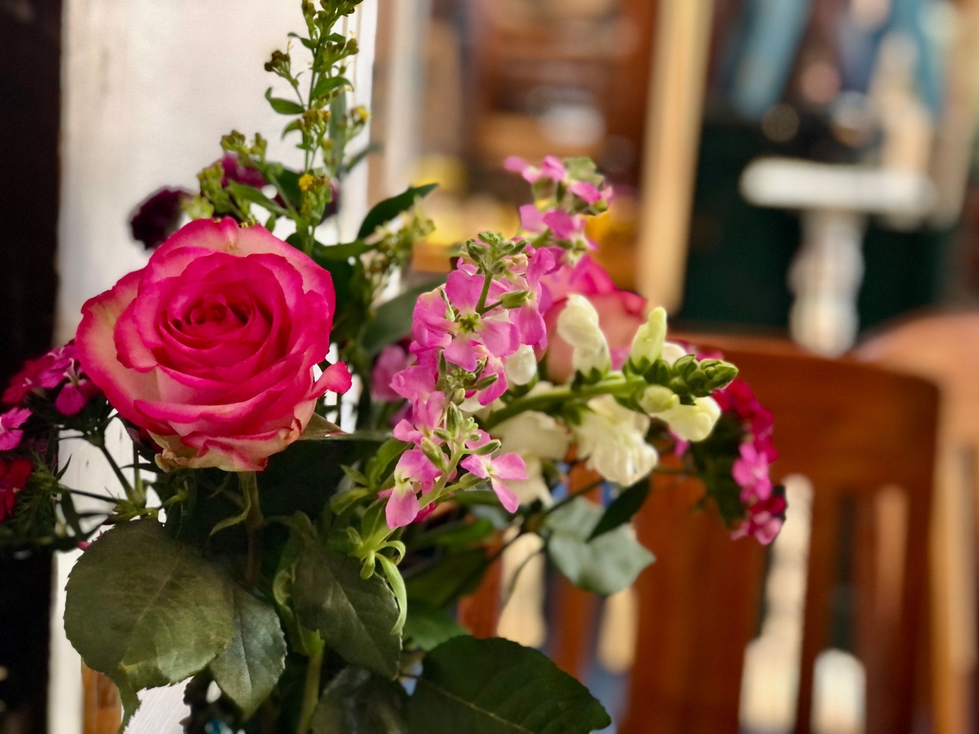 A bouquet of pink and white flowers in a vase on a table.