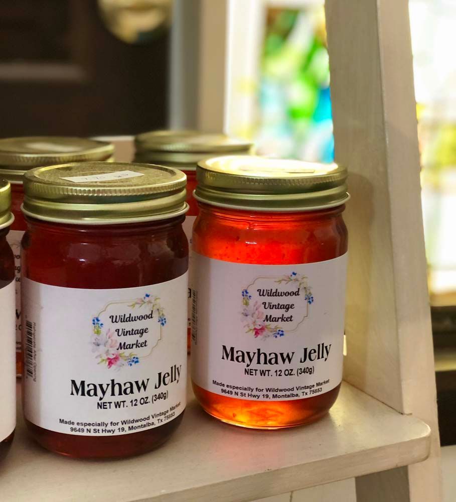 Two jars of mayhaw jelly are on a shelf