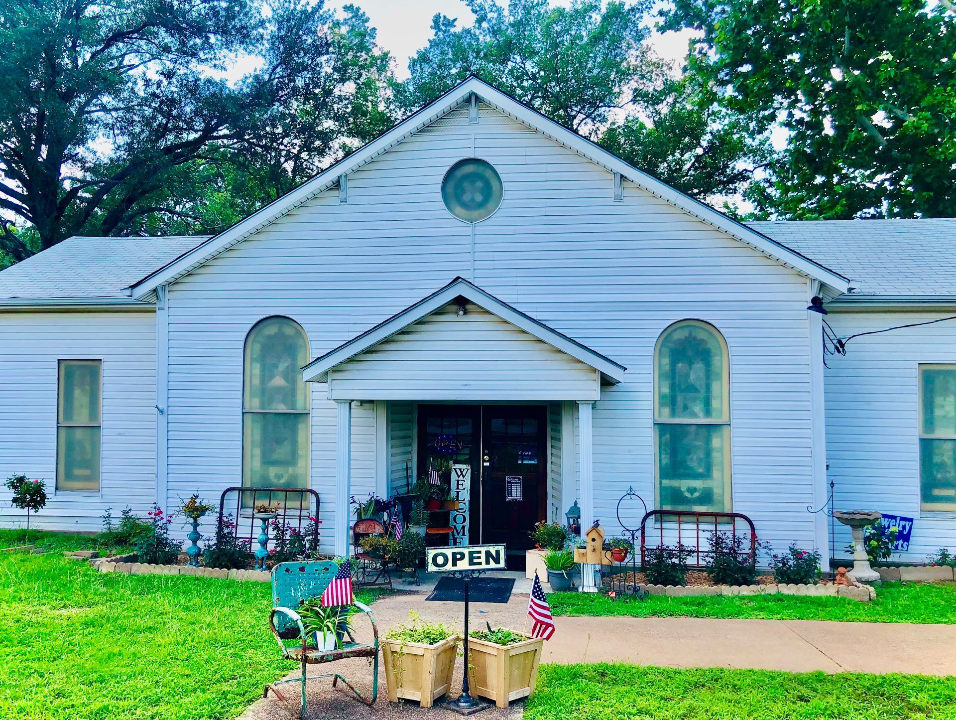 A white house with a sign that says open in front of it