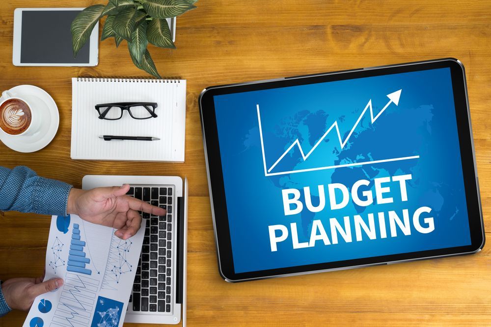 A Person Is Using A Laptop And A Tablet To Plan Their Budget — Wagga Tradesman Accounting Services In Wagga Wagga, NSW
