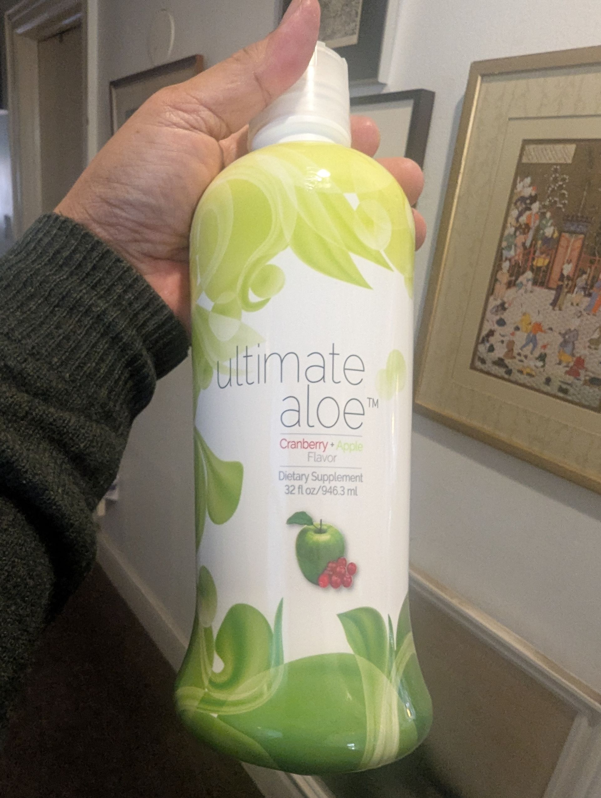 A person holding a white and green bottle of