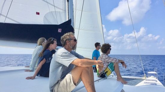 Ted and crew sitting aft overlooking the catamaran
