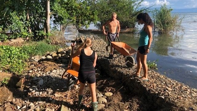 Missionaries working at the safe house moving rocks