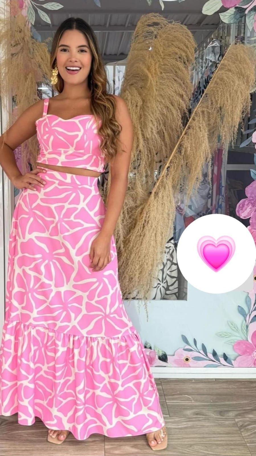 Una mujer lleva un top rosa y una falda rosa.