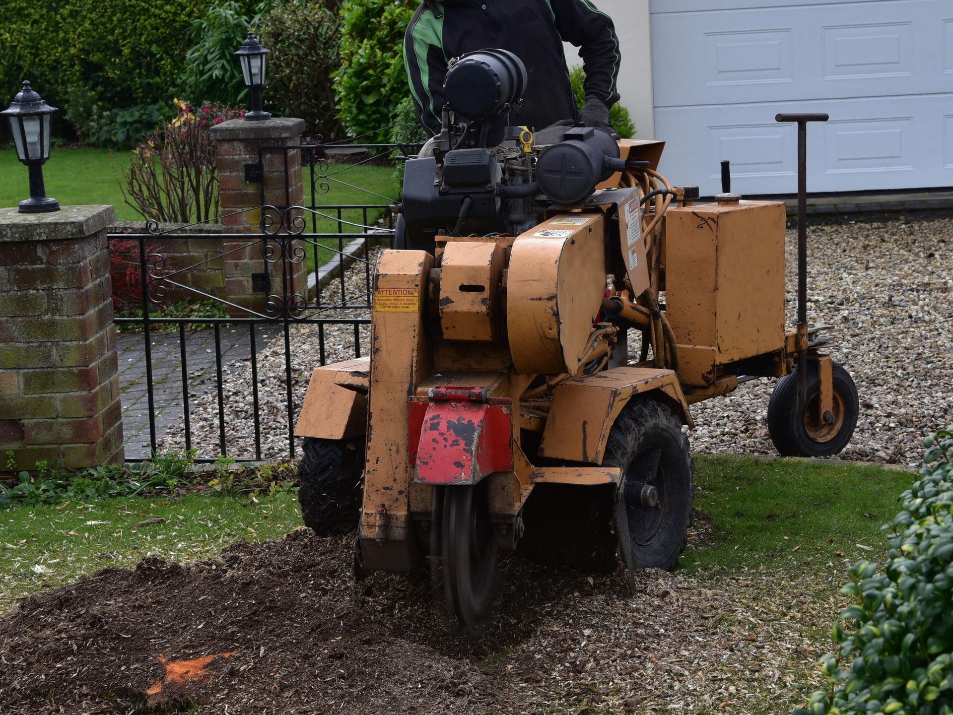A tree stump grinding machine in a residential yard.