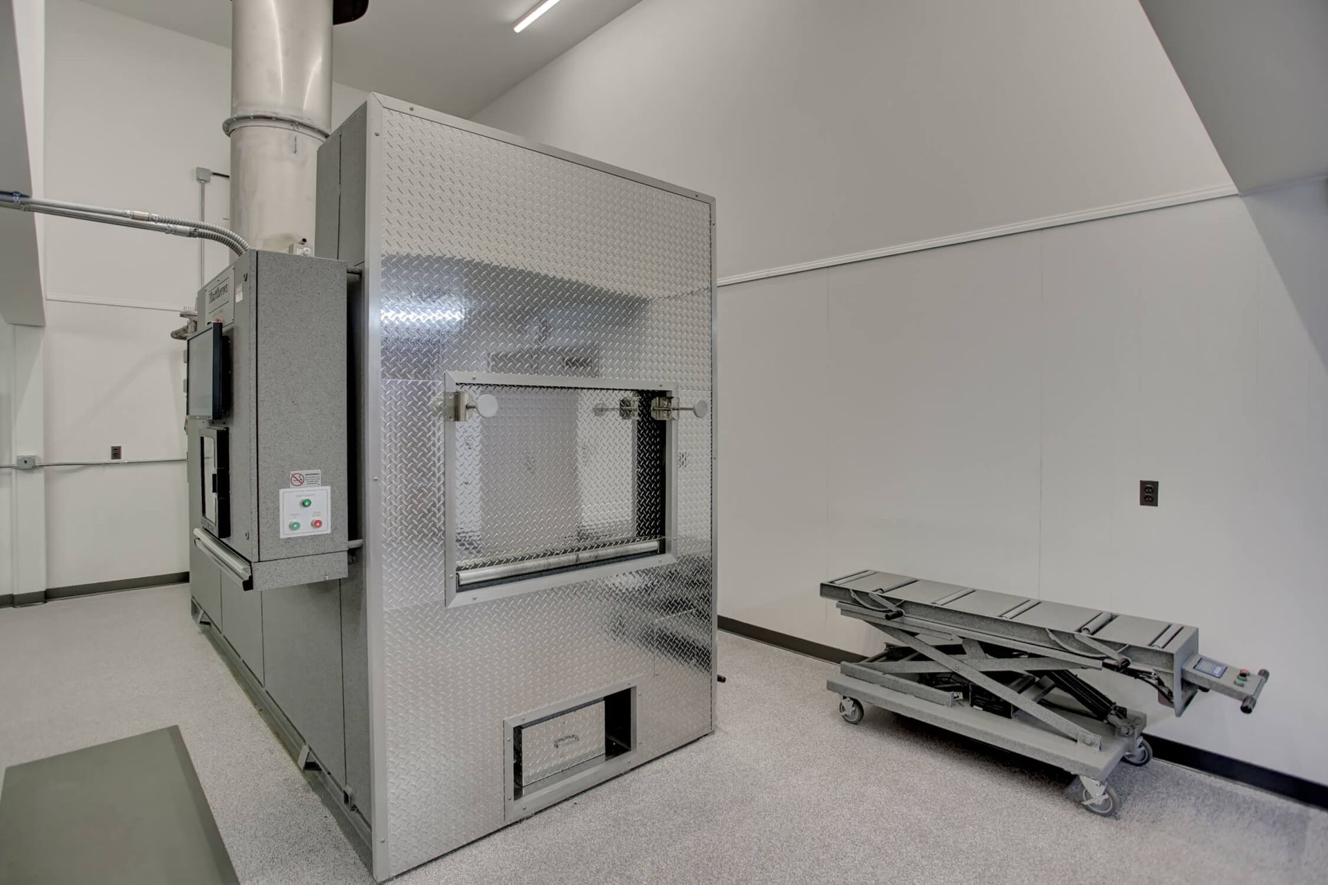 A room with a machine and a stretcher in it.
