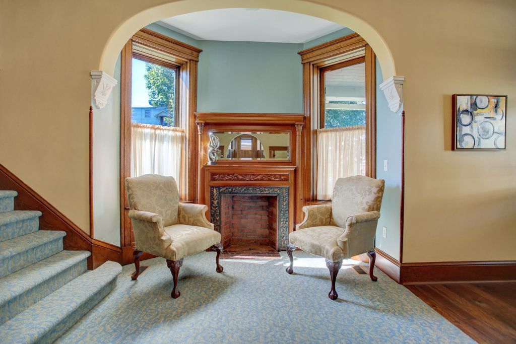 A living room with two chairs and a fireplace.