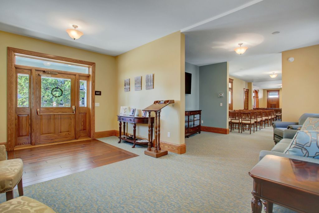 A living room with a couch , table , chairs and a wooden door.