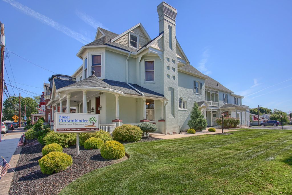 A large white house with a large lawn in front of it.