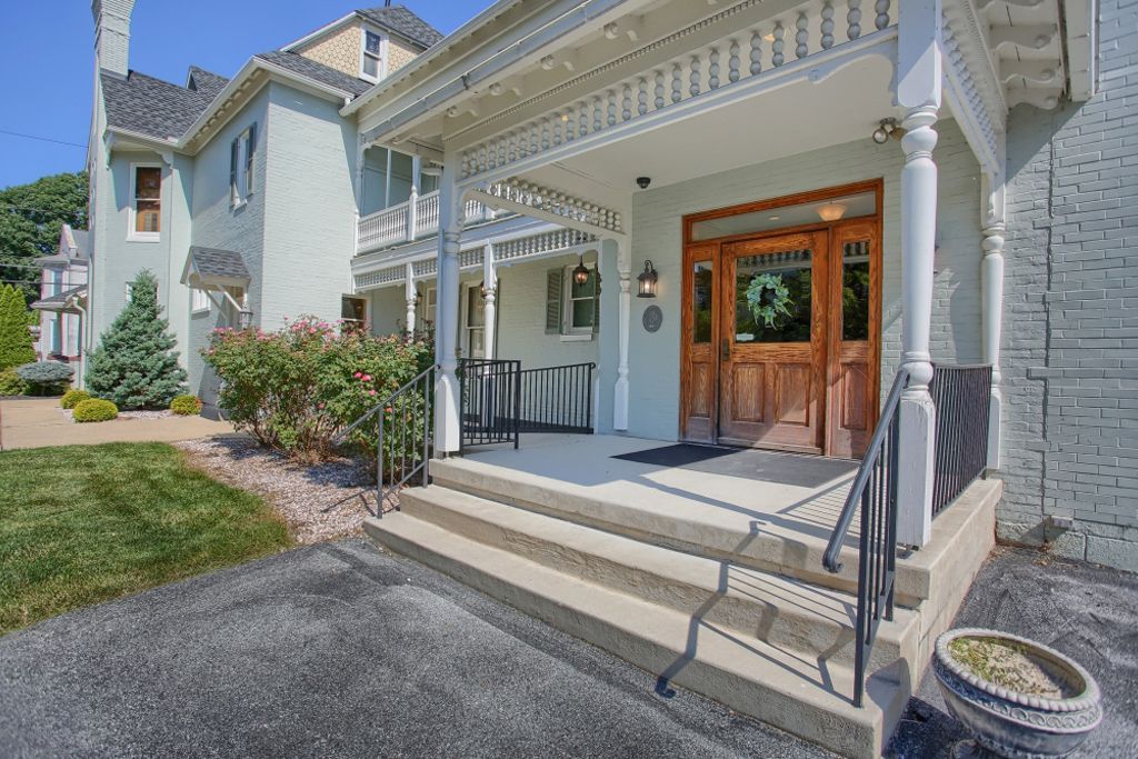 A large house with a large porch and stairs leading up to it.