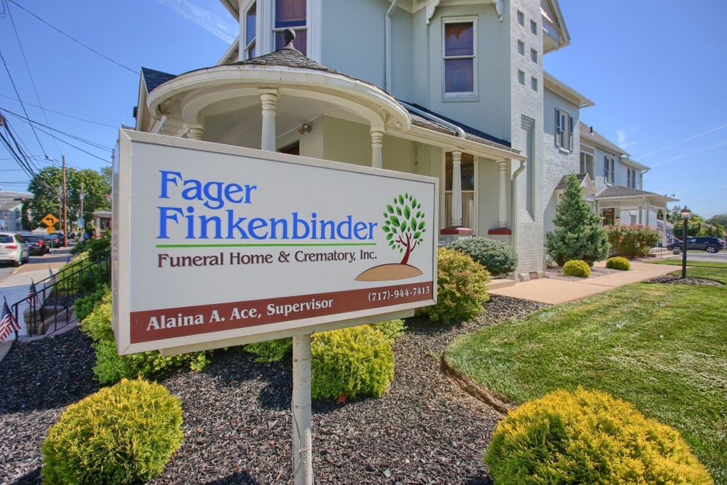 A sign for fager finkenbinder funeral home is in front of a house