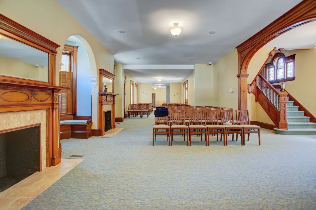 A large room with a fireplace and chairs in it