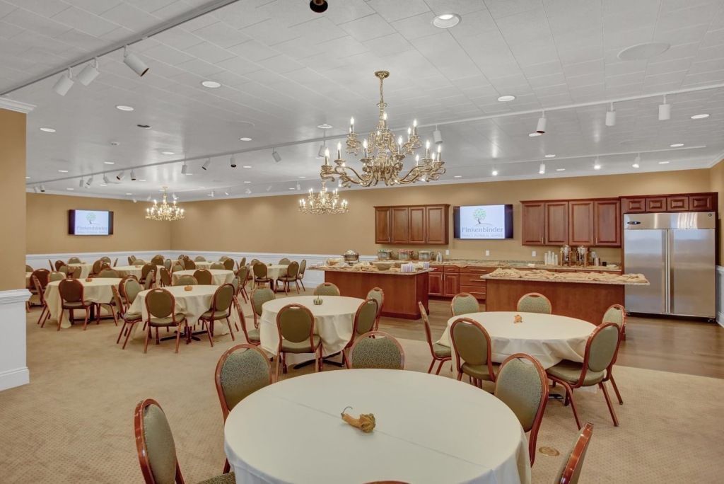 A large room with tables and chairs and a chandelier