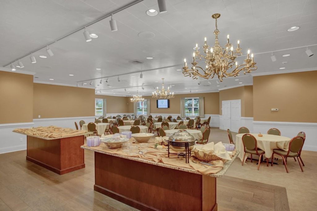 A large room with tables and chairs and a buffet table.