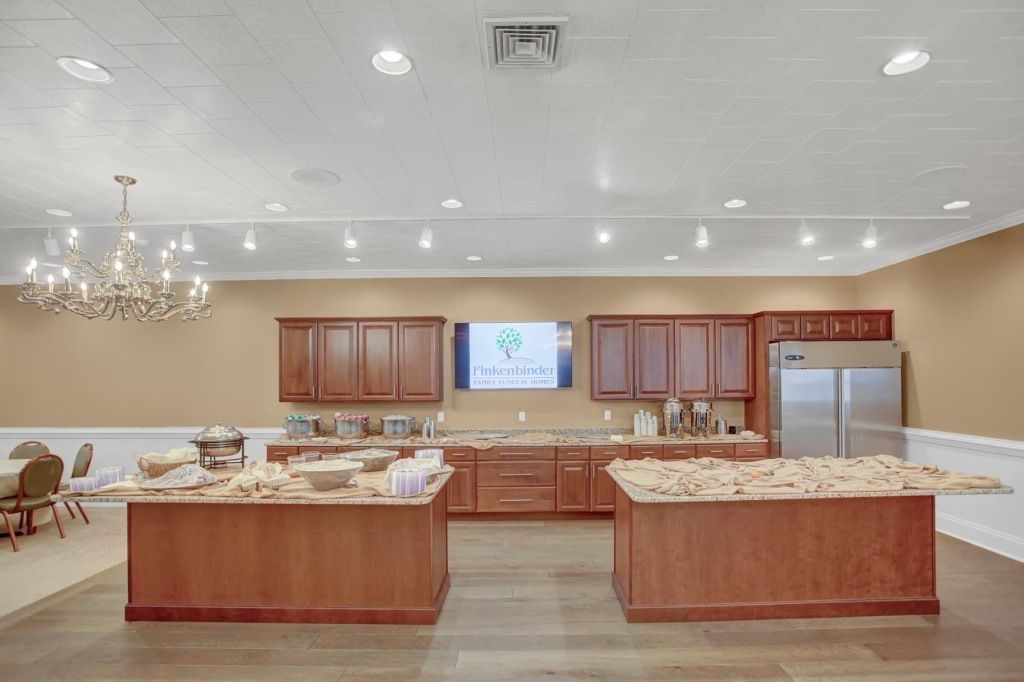 A large kitchen with two islands and a refrigerator.