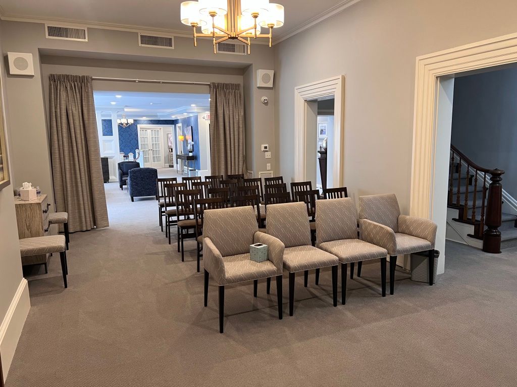 A waiting room with a lot of chairs and a chandelier.