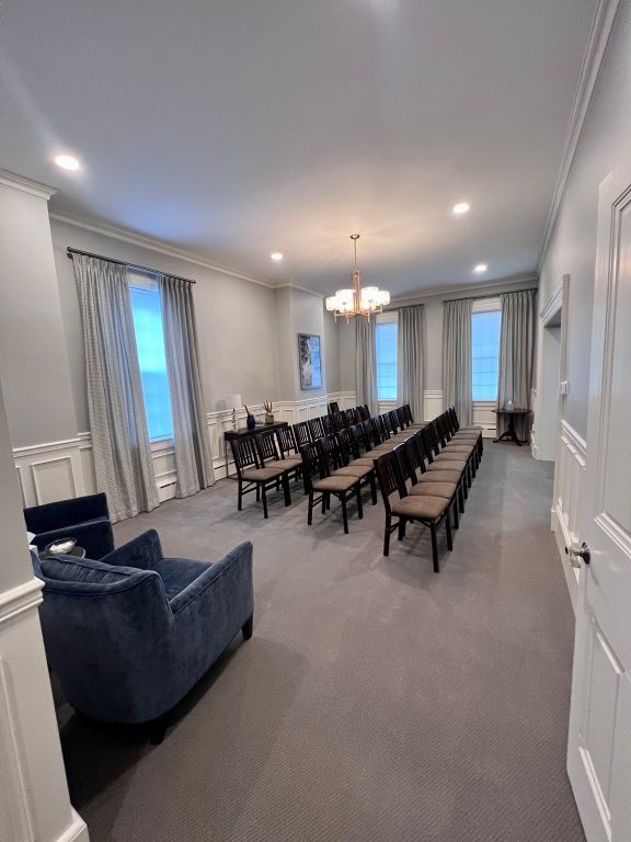A large room with a lot of chairs and a chandelier.