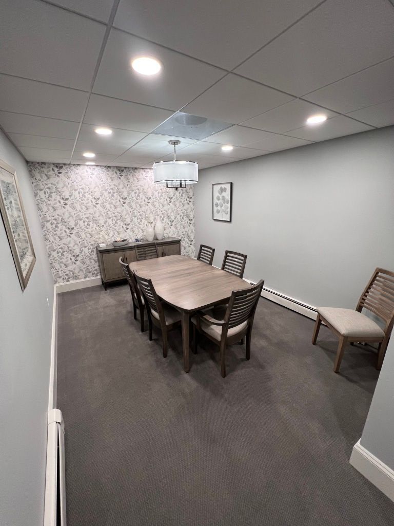 A conference room with a long table and chairs.