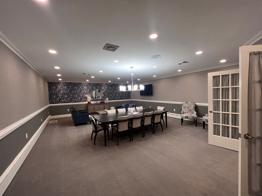 A large room with a long table and chairs in it.