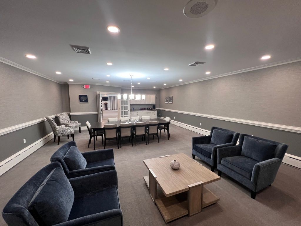 A living room with a table , chairs , and a coffee table.