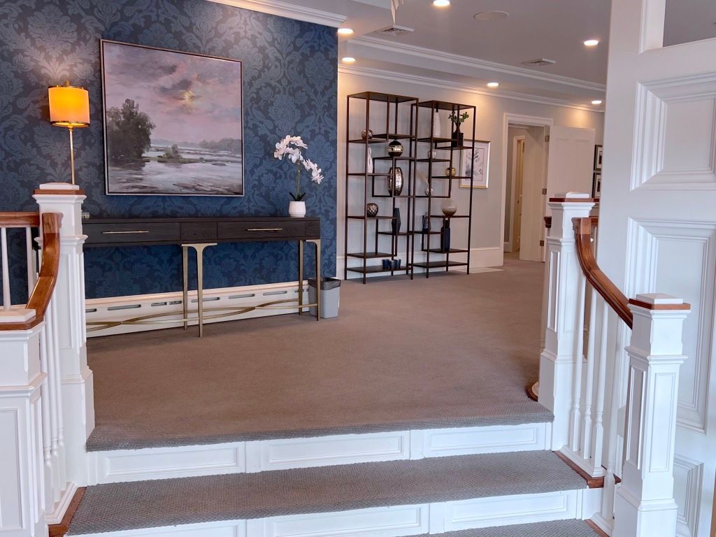 Stairs leading up to a room with a painting on the wall
