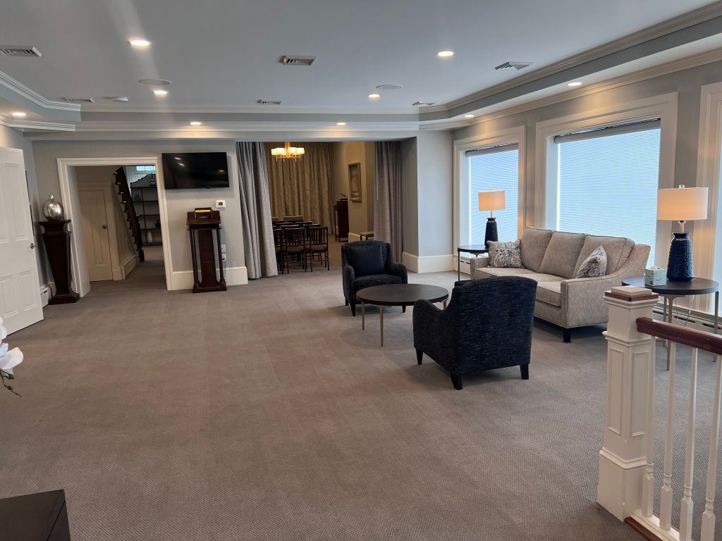 A living room with a couch , chairs , tables and a television.