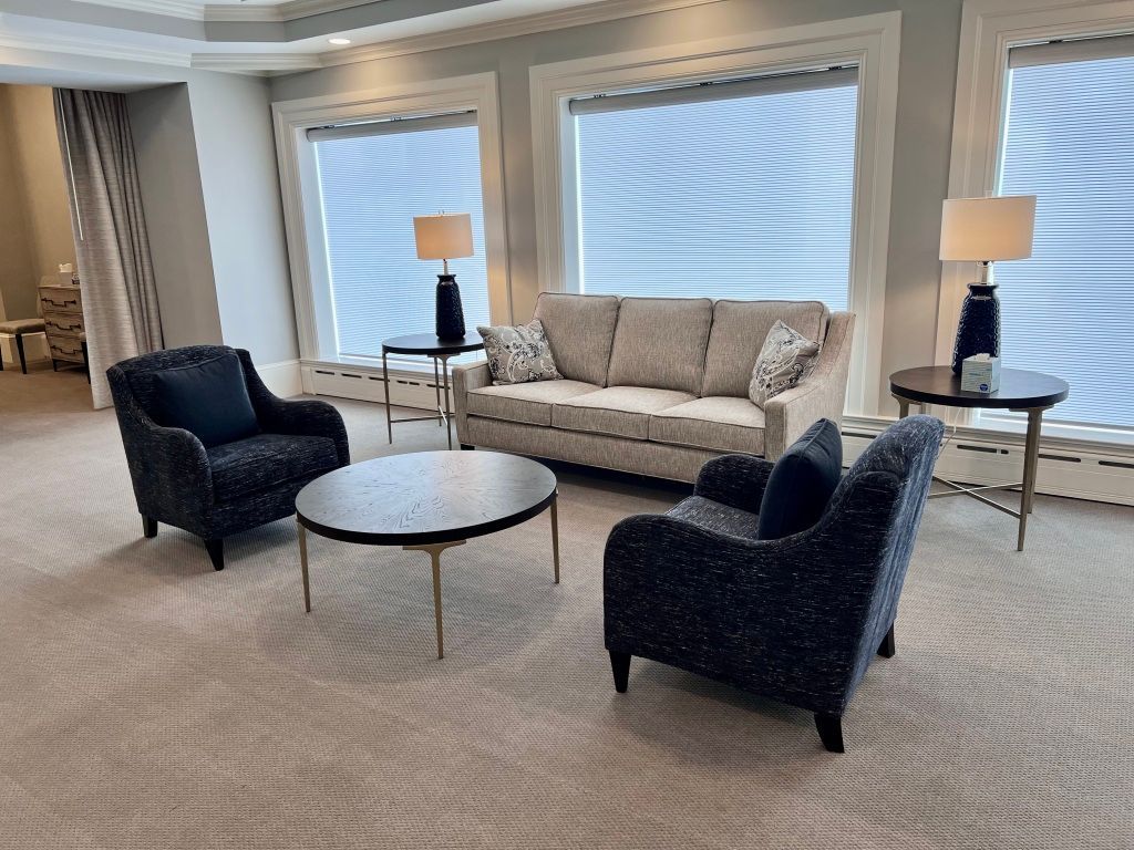 A living room with a couch , chairs , and a coffee table.