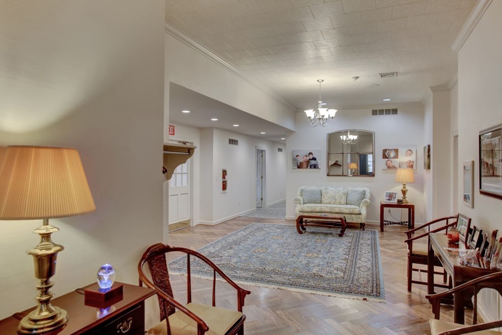 A living room with a couch and chairs and a lamp