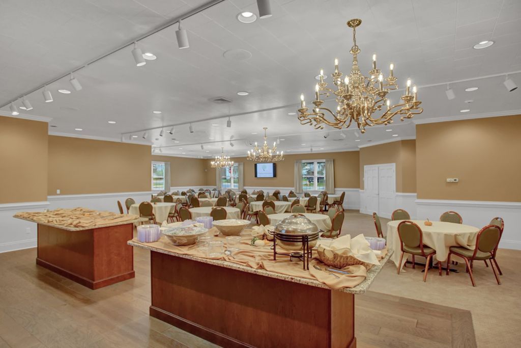 A large room with tables and chairs and a buffet table.