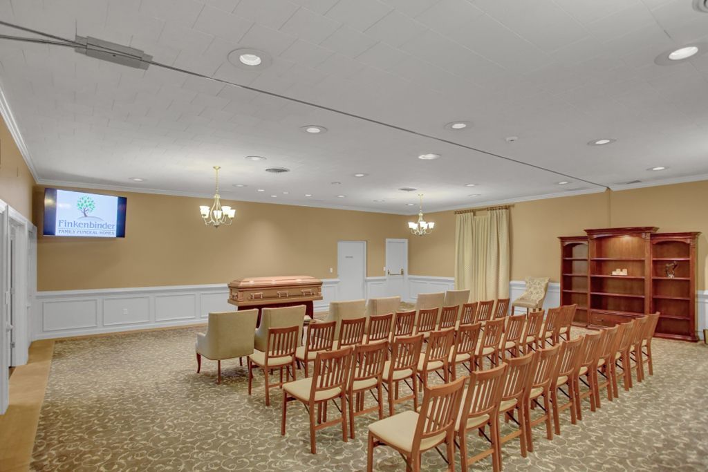A large room with rows of chairs and a piano.