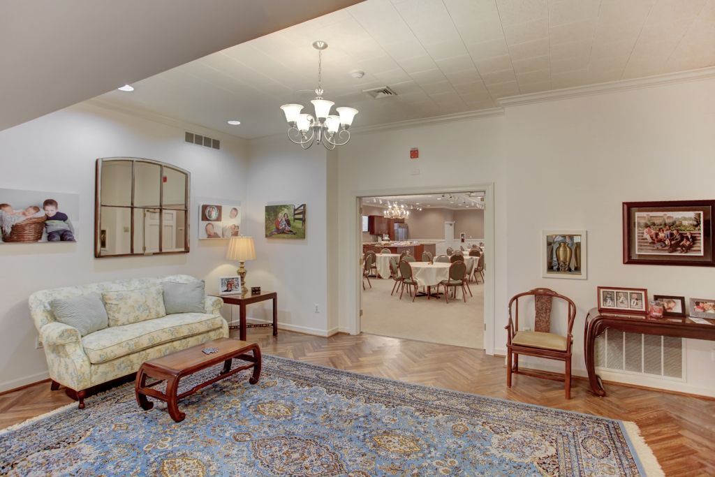 A living room with a couch , table , chairs and a rug.