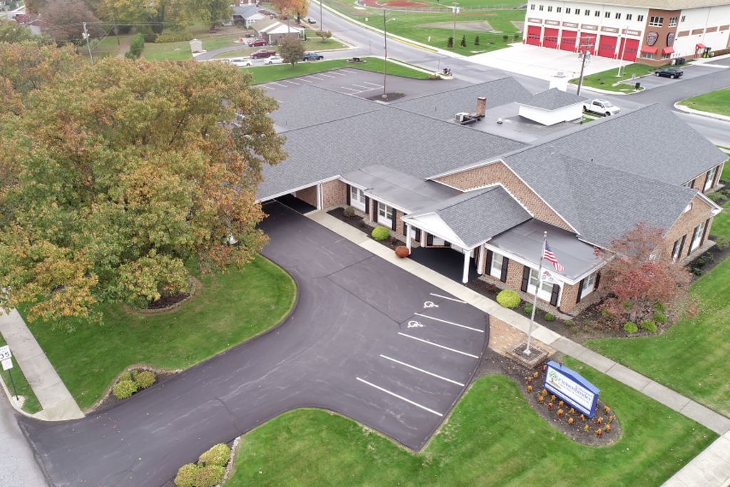An aerial view of a large building with a parking lot in front of it.