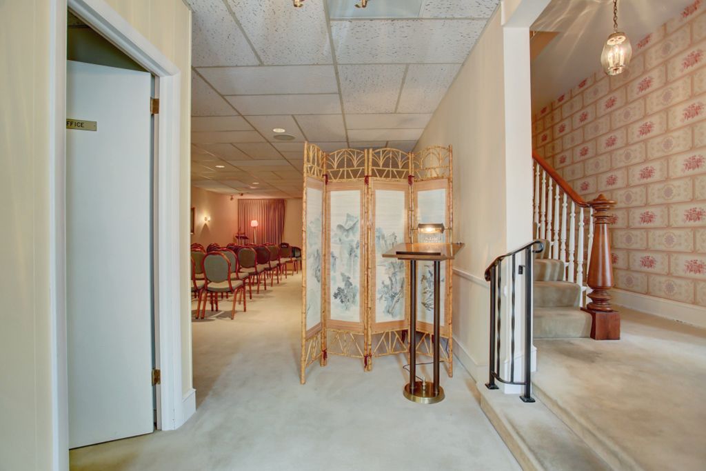 A hallway with a staircase and a room divider