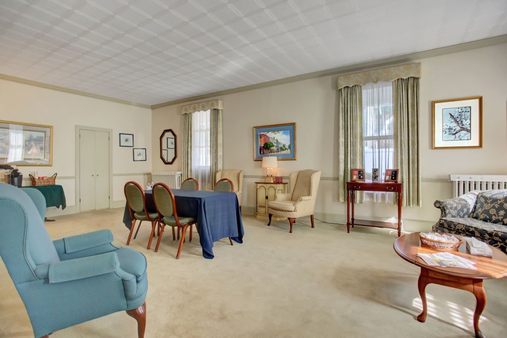A living room with a table and chairs in it
