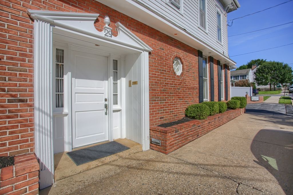 The front door of a brick building with a white door