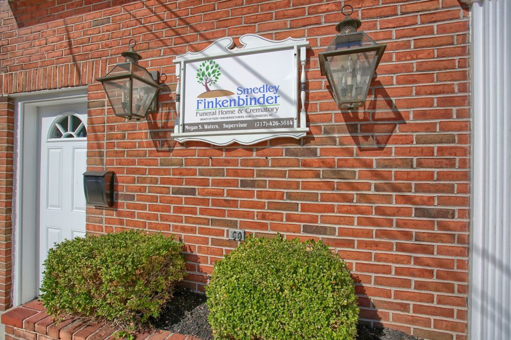 A brick building with a white door and a sign on it