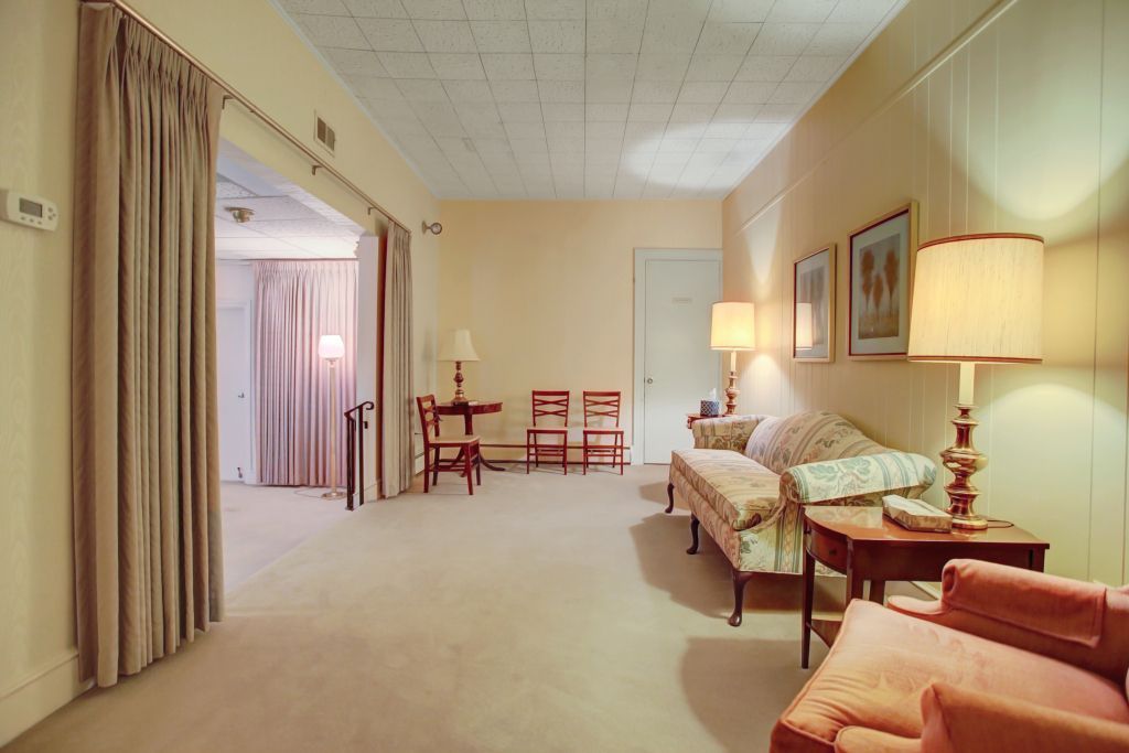 A living room with a couch and chairs and lamps